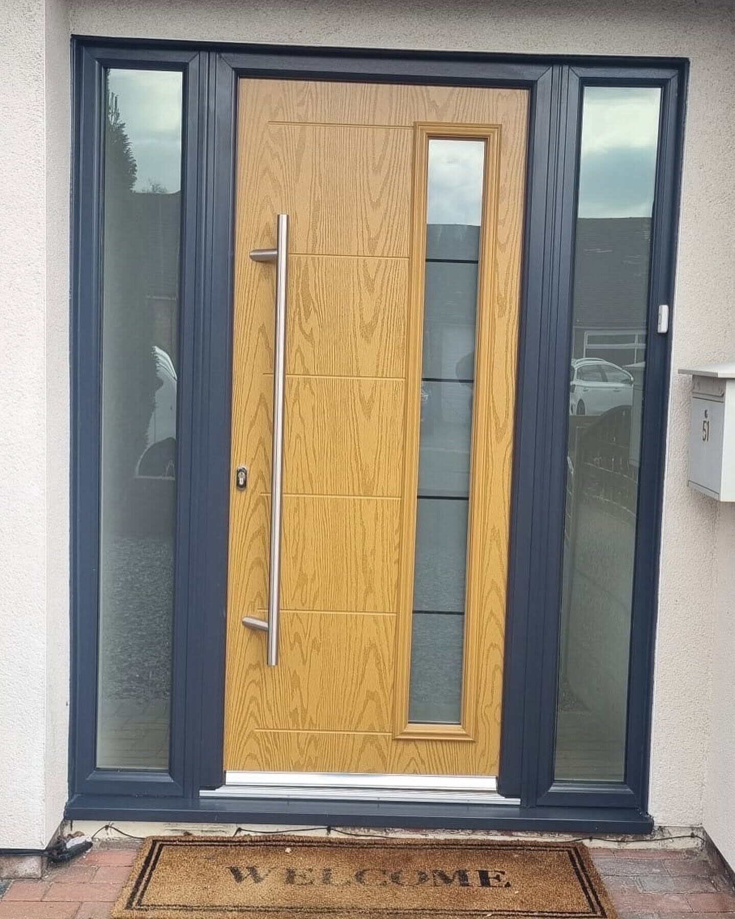 Oak-effect composite front door with a glazed side panel
