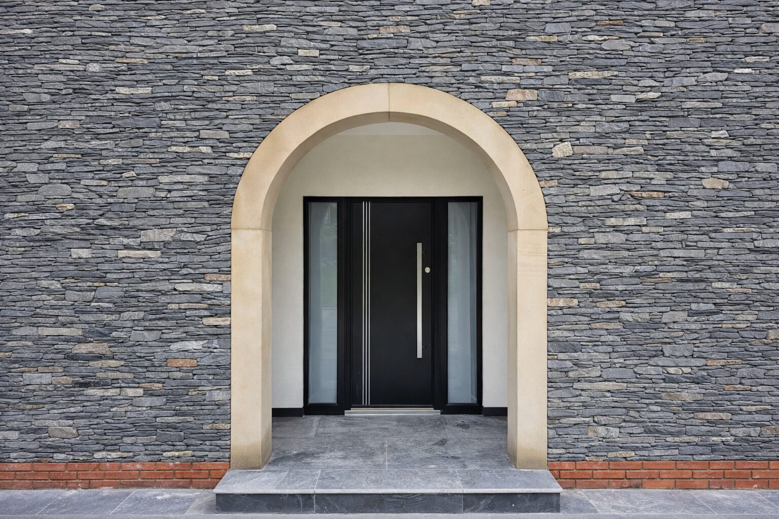 Black composite front door with a long bar handle, set in a stone arch