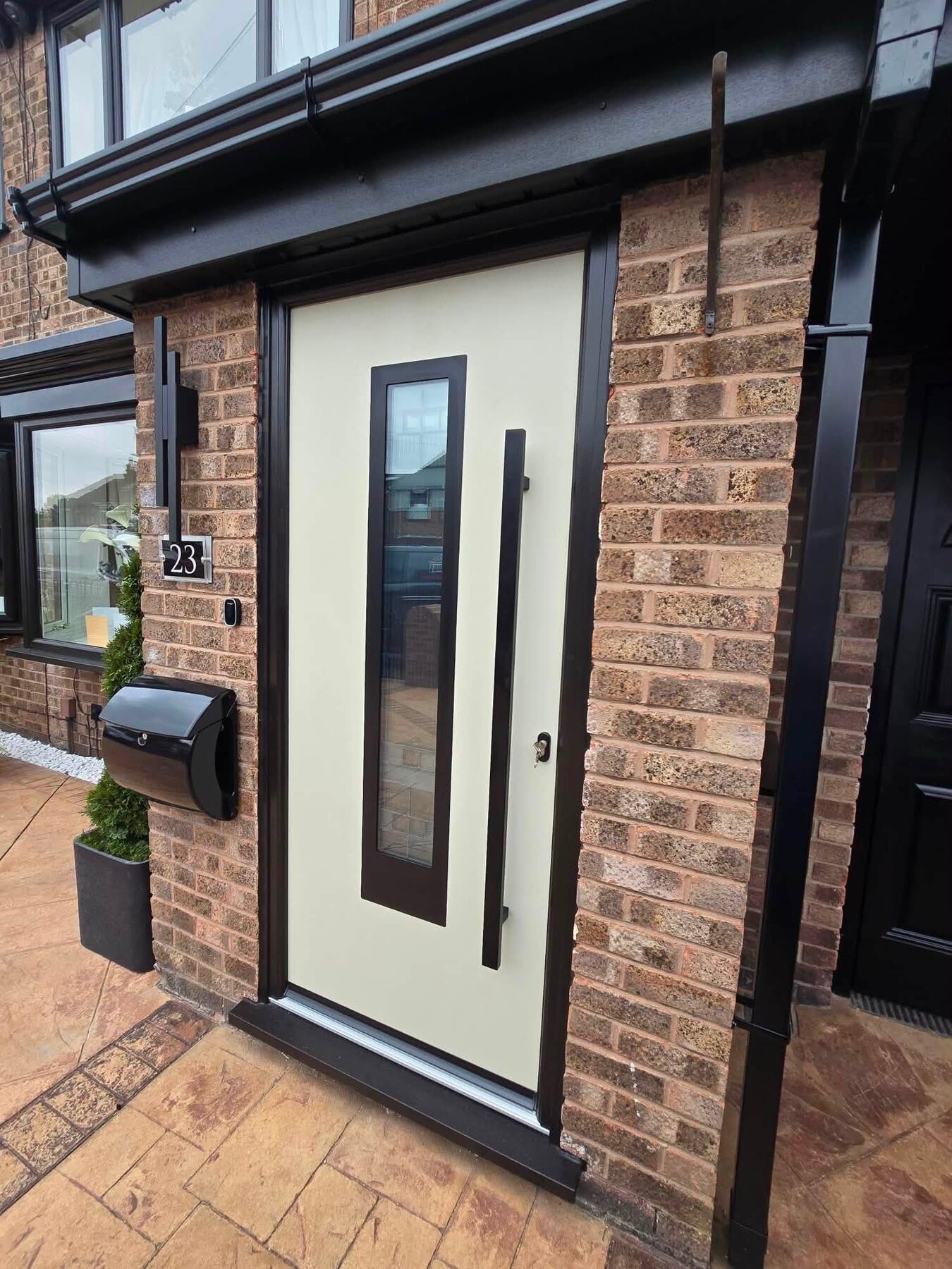Dark composite front door with a glazed side panel