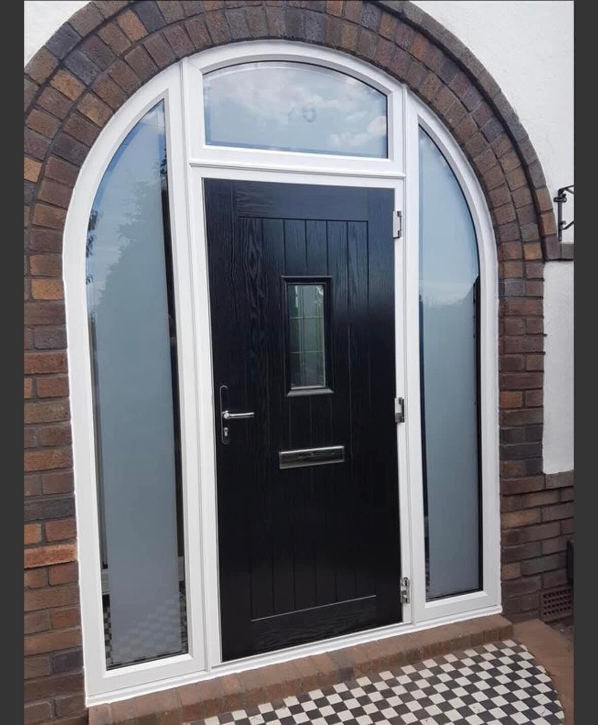 Black front door in an arched brick surround