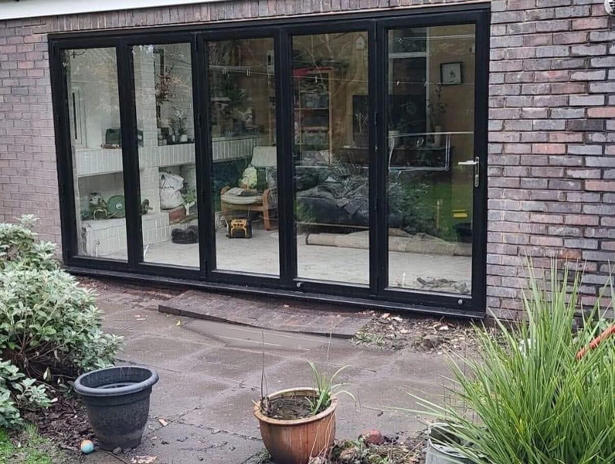 Black aluminium bi-fold doors on a brick house