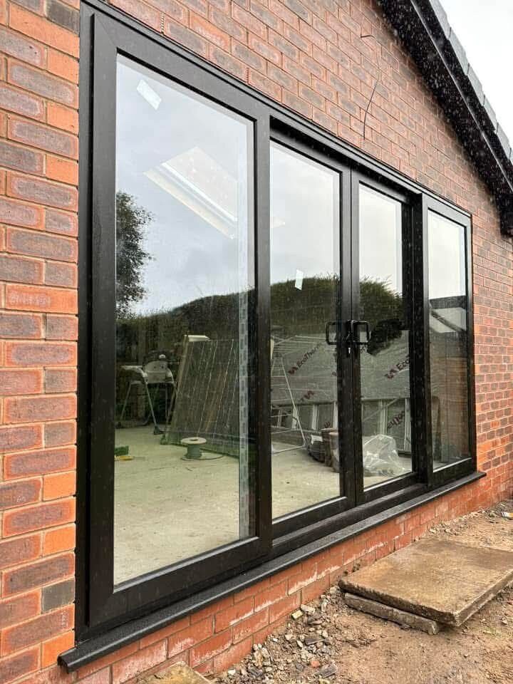 Large black picture window on a brick wall