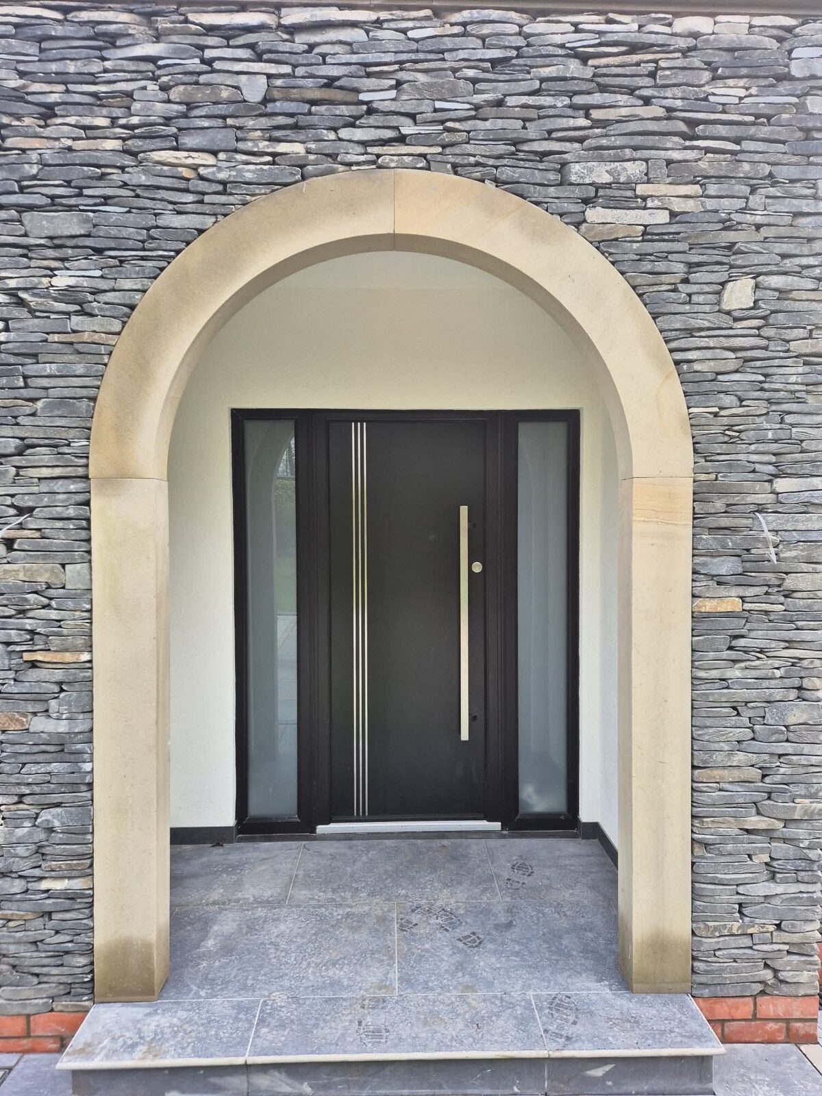 Dark front door set in a stone arch
