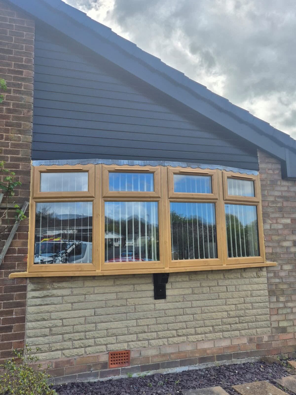 Oak-effect bay window on a rendered bungalow
