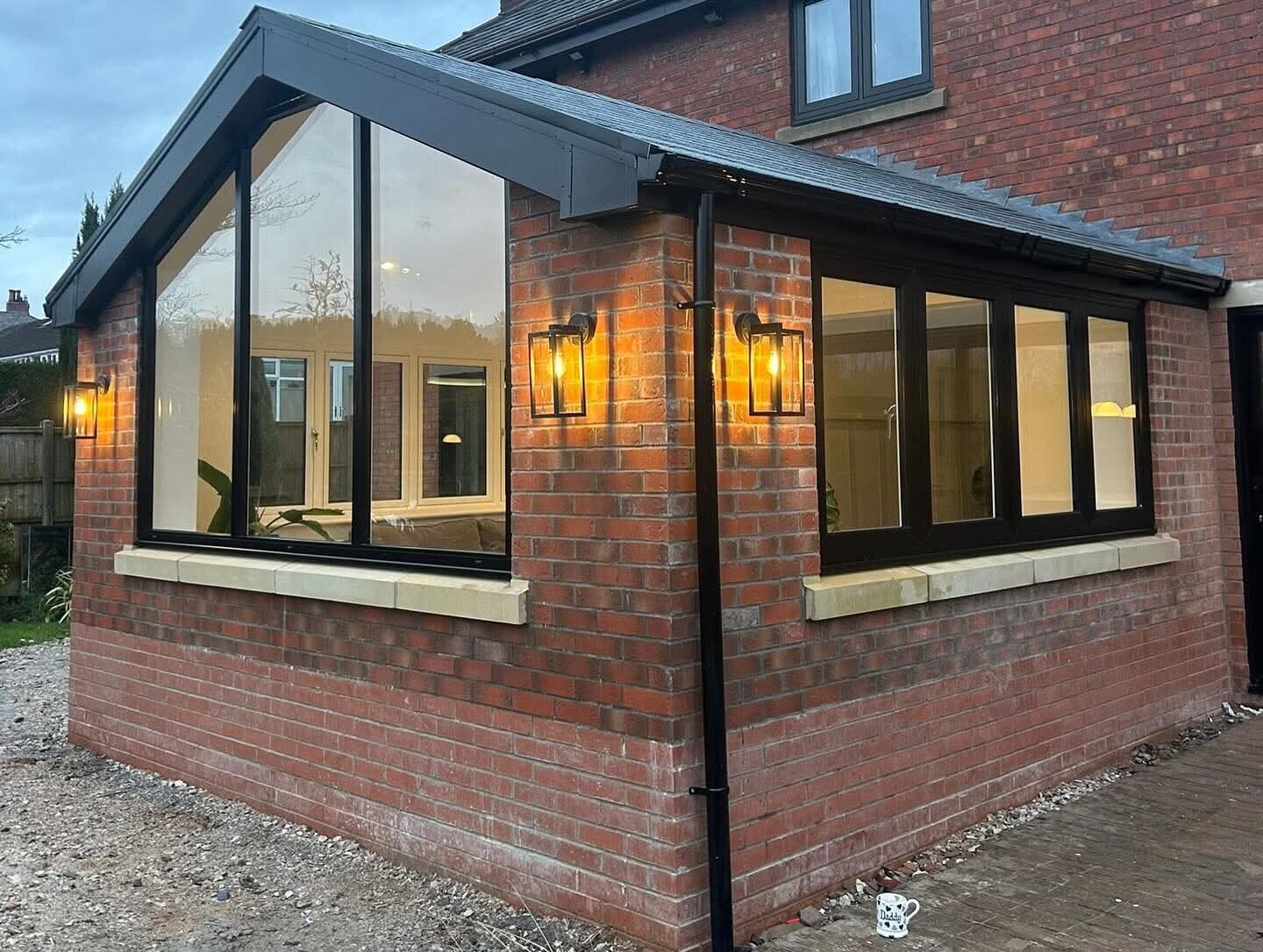 Orangery lit at dusk with anthracite frames