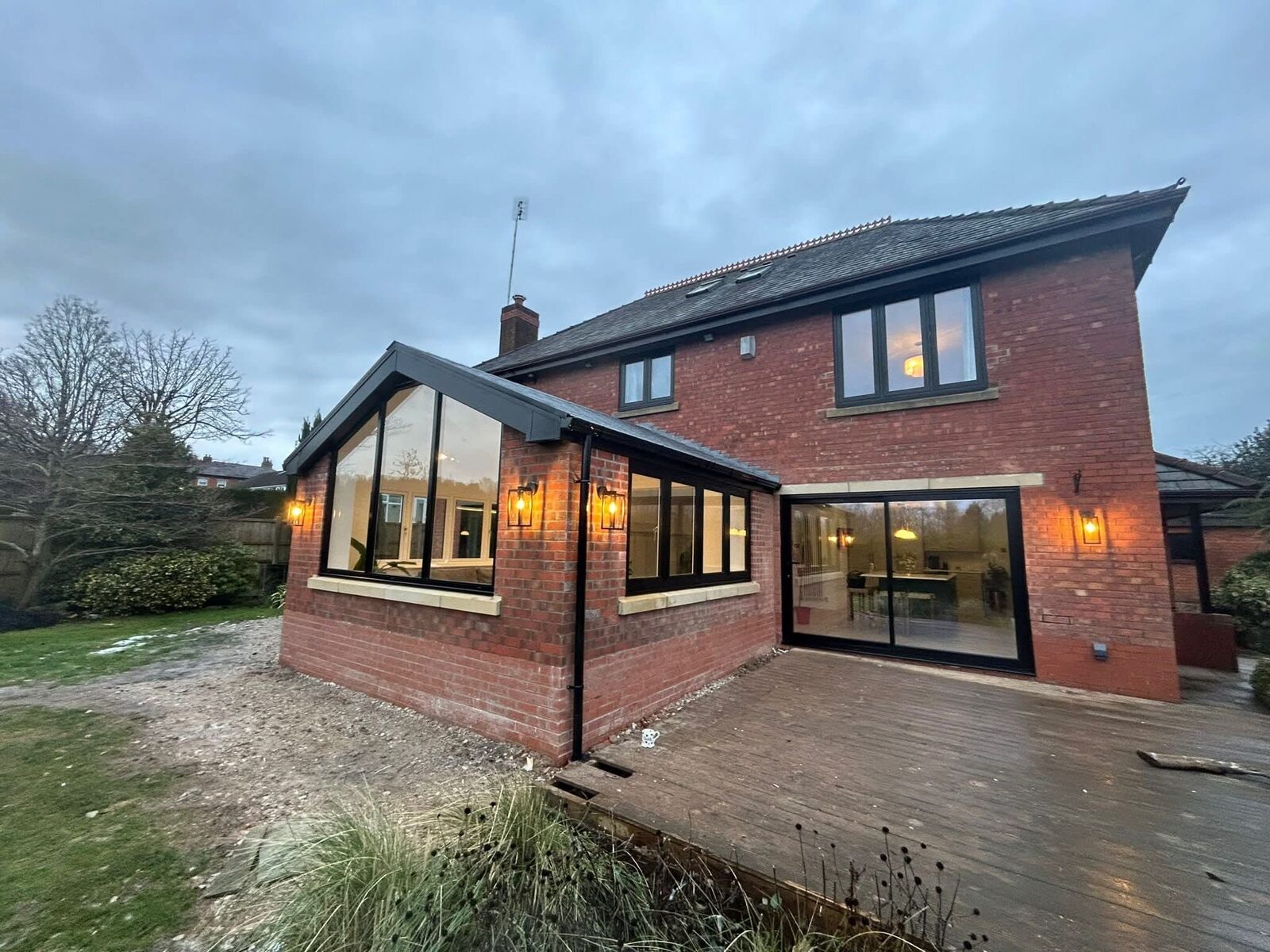 Rear extension lit at dusk with full-height glazing