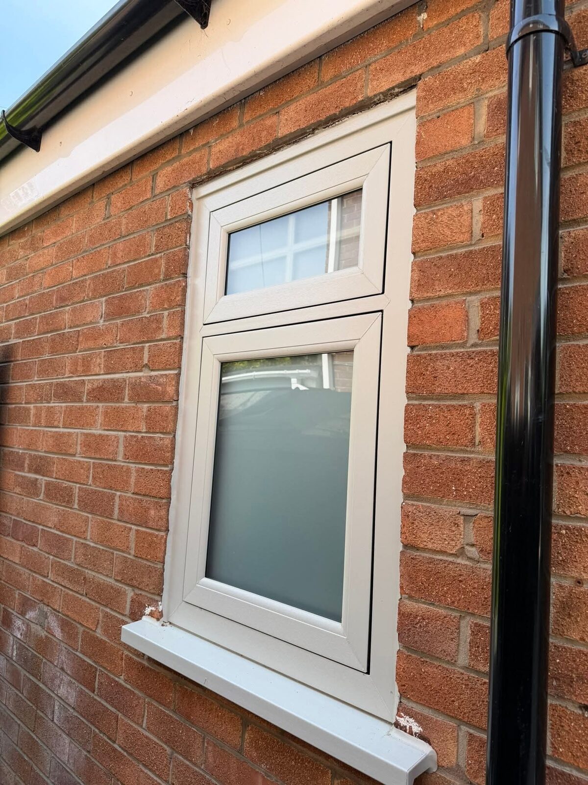 White uPVC window on a red brick wall